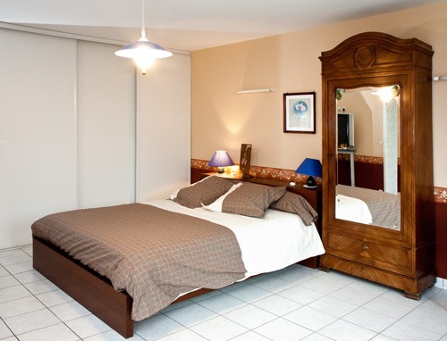 Chambre du gîte Marjorie avec armoire ancienne